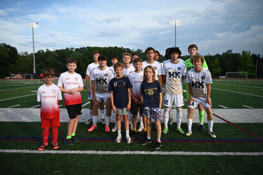 A youth group on the field with RUAC players at a home match