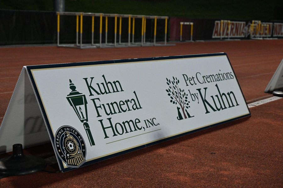 A partner A-frame sign on the track beside the field at Alvernia University