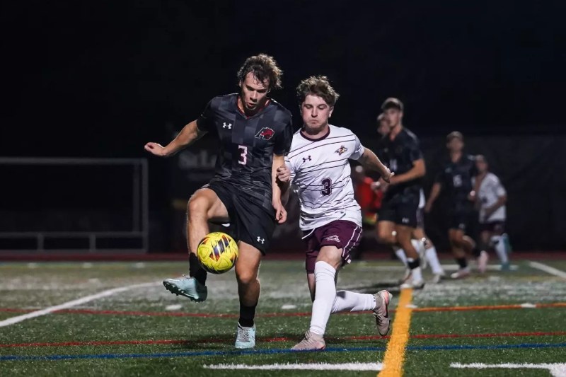 Aidan Courtney, in white No. 3, chases the ball for Alvernia University
