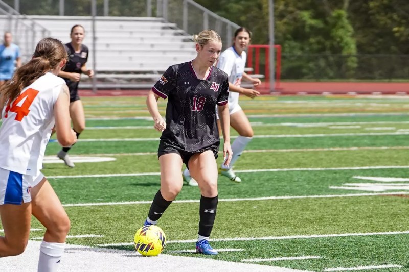 Sarah Ashley, in black No. 18, dribbles for Alvernia University