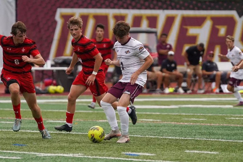 Aidan Courtney, in white, dribbles for Alvernia University